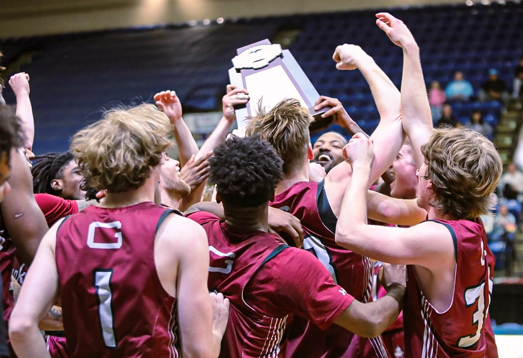 Guilford College - Men's Basketball team holding up trophy 